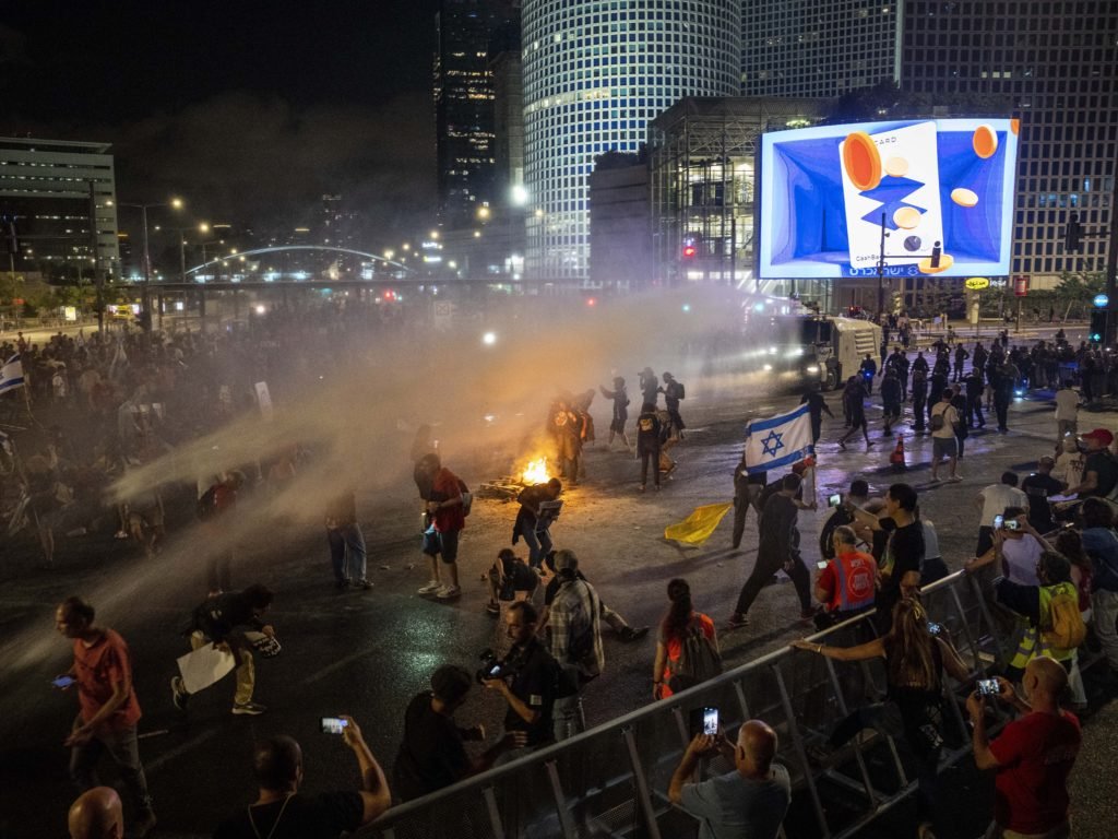 Police use water cannon to disperse demonstrators during a protest against Israeli Prime Minister Benjamin Netanyahu's government, and calling for the release of hostages held in the Gaza Strip by the Hamas militant group, in Tel Aviv, Israel, Saturday, May 25, 2024. (AP Photo/Ariel Schalit)